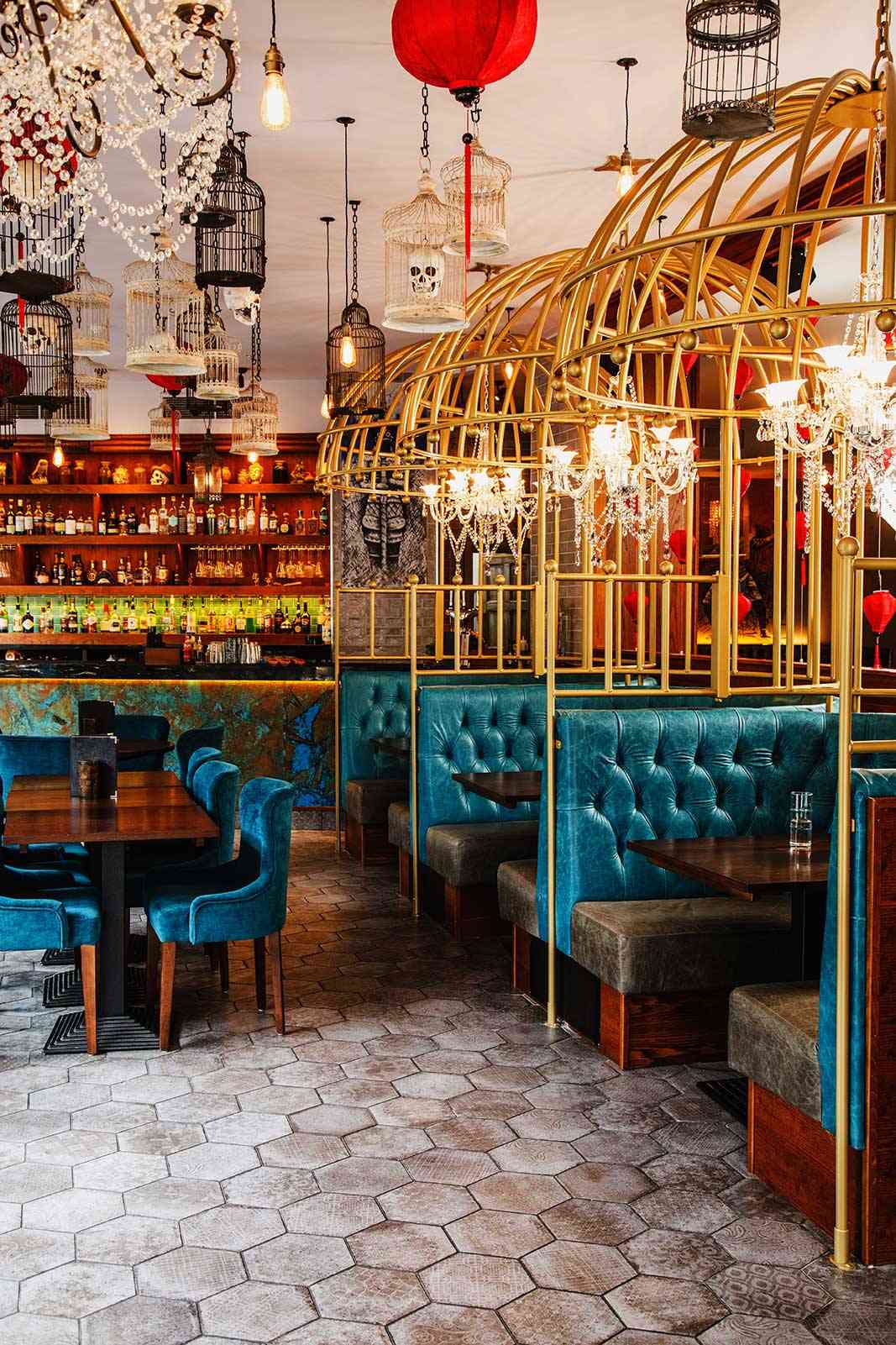 Hexagon tiled floor leading past the birdcage booths to the bar at Siamais