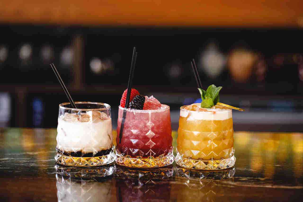 Three hand-made cocktails lined up on the bar at Siamais