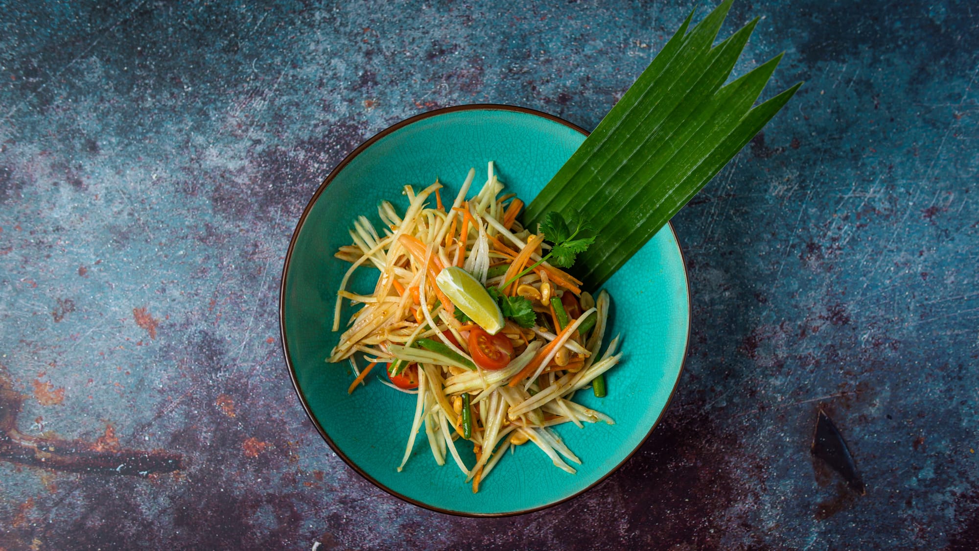 Som tam papaya salad in a teal bowl