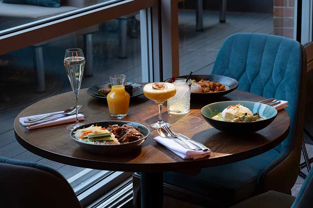 A bottomless brunch table by the window at Siamais Birmingham