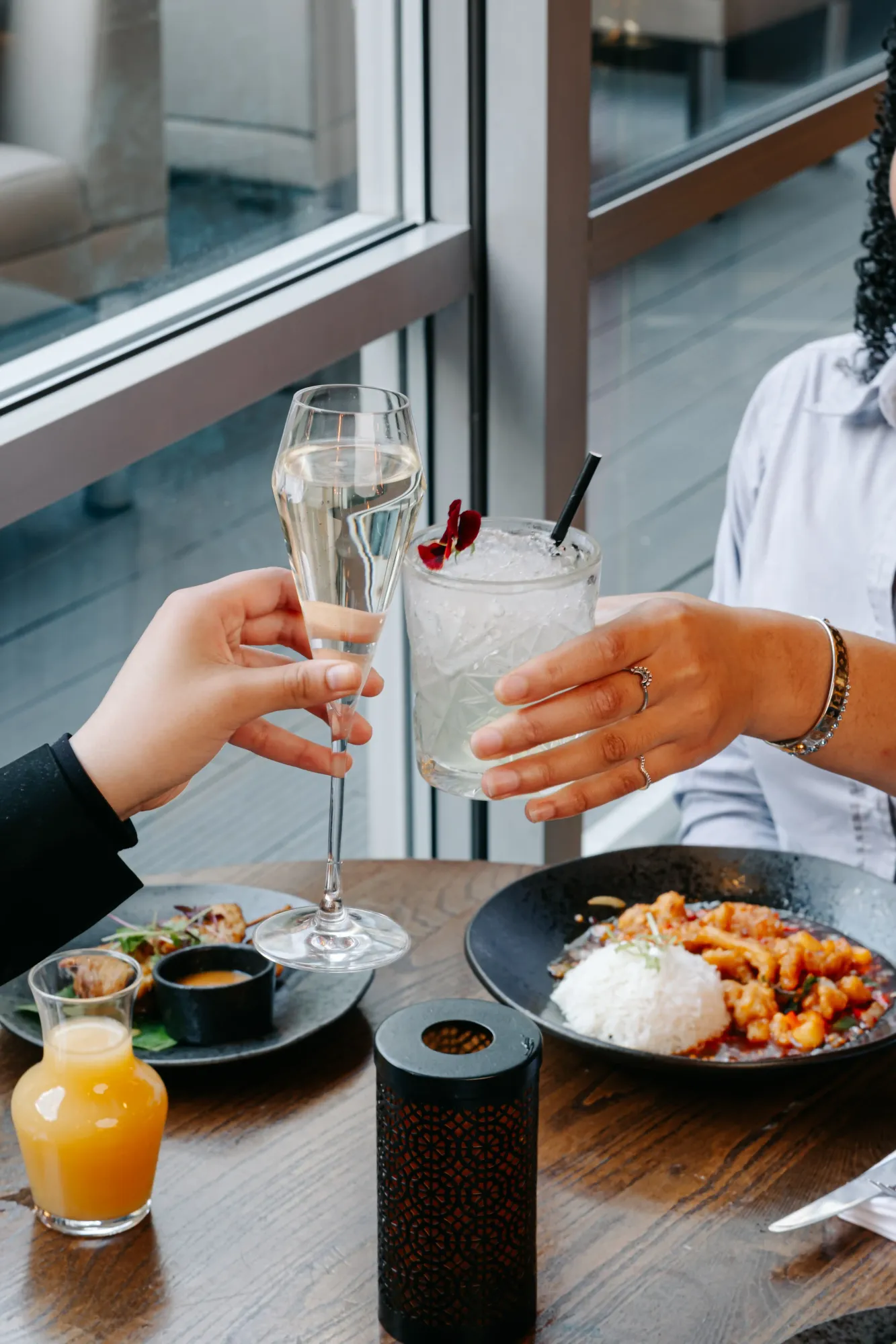 Guests raising Prosecco and mocktails over a Thai bottomless brunch