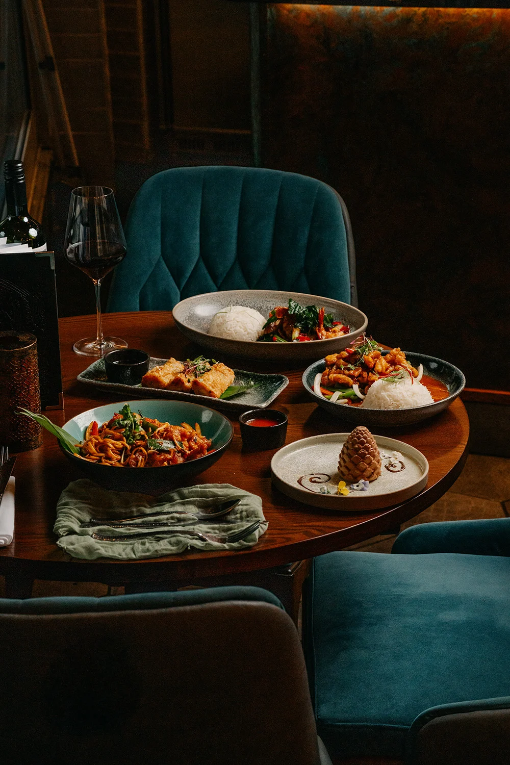 Thai dishes and festive cocktails on a booth table at Siamais at Christmas